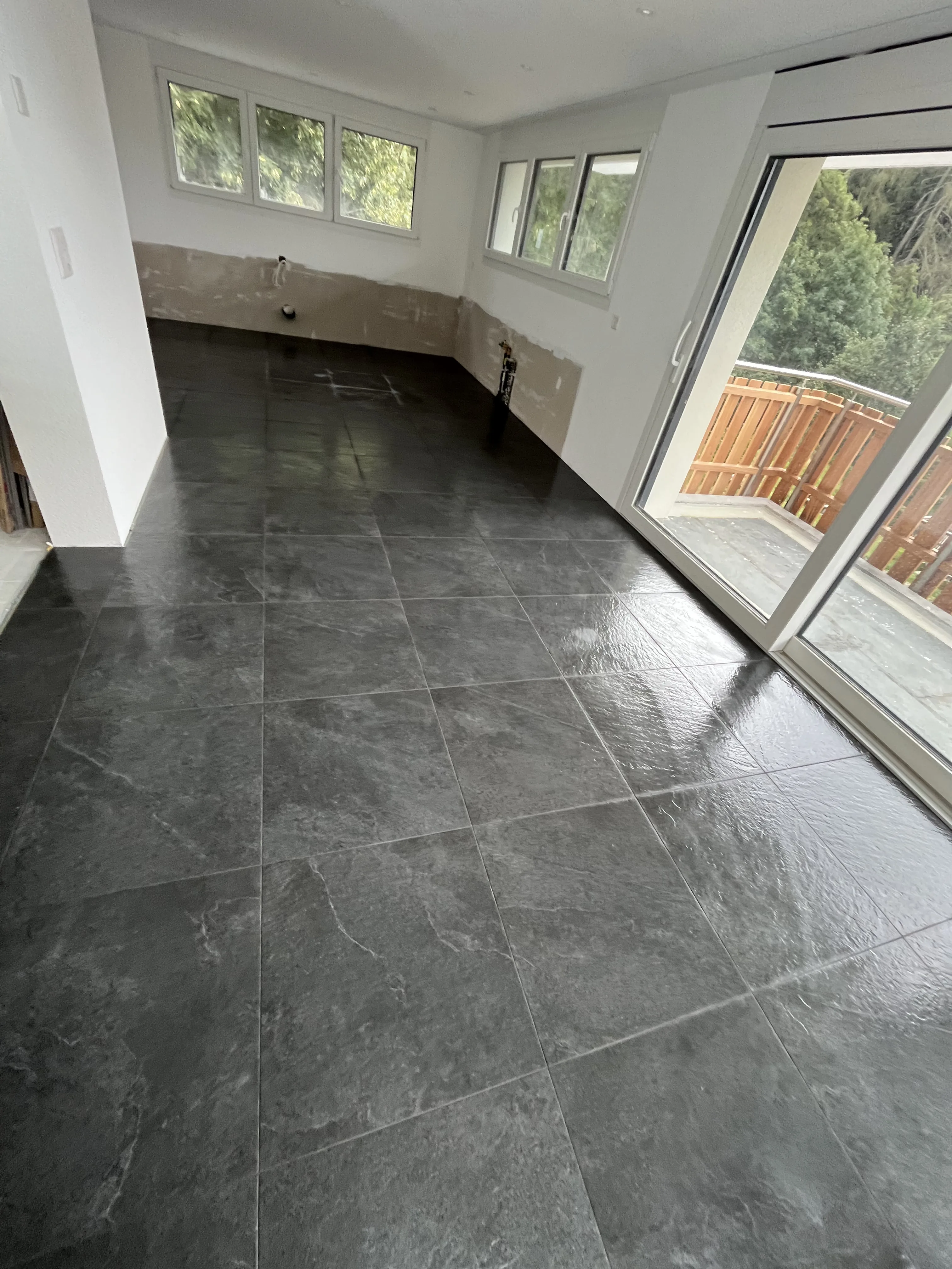 Renovierter Wohnraum mit dunklem Steinfussboden