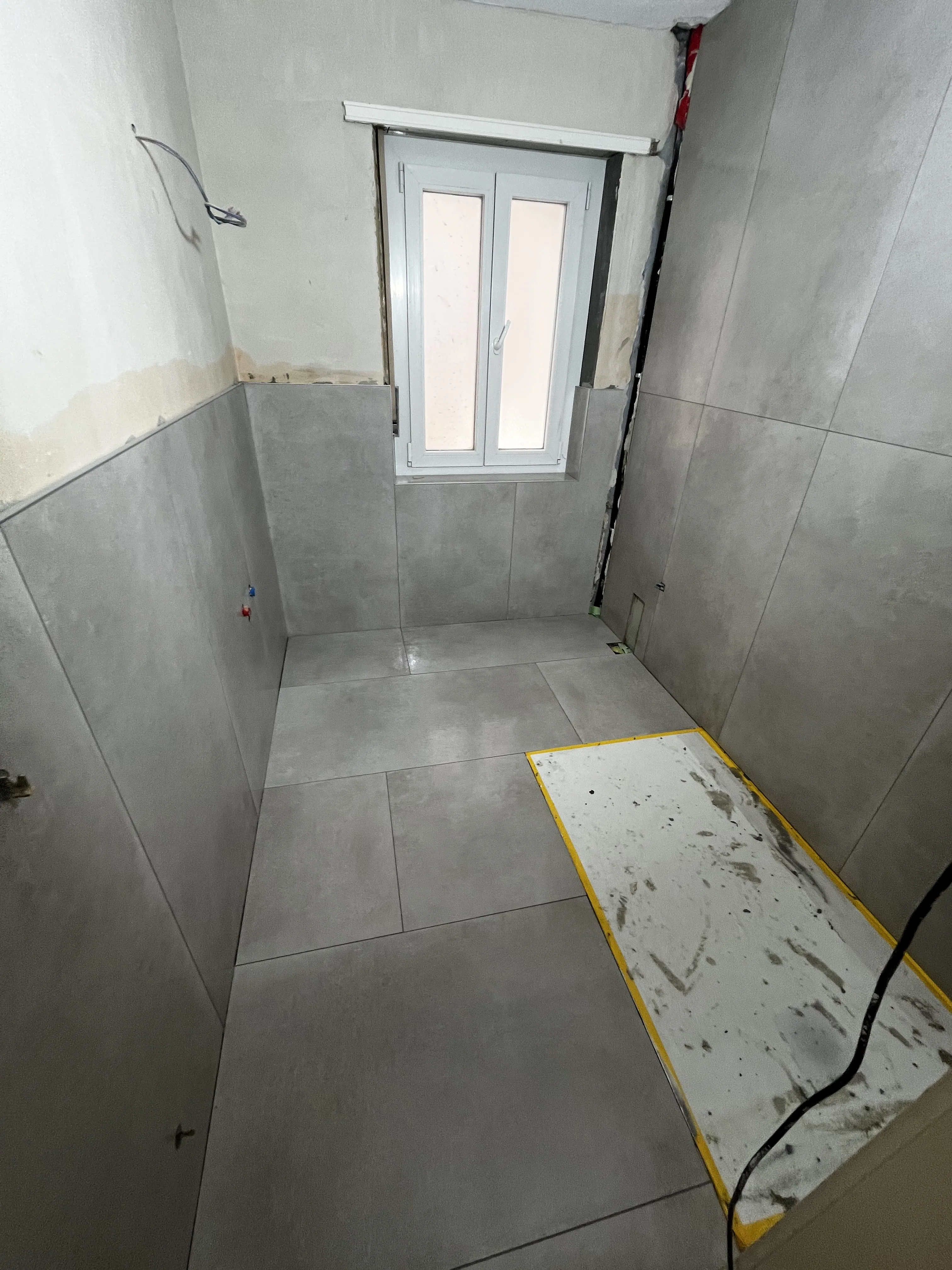 Badezimmersanierung mit modernen grauen Fliesen