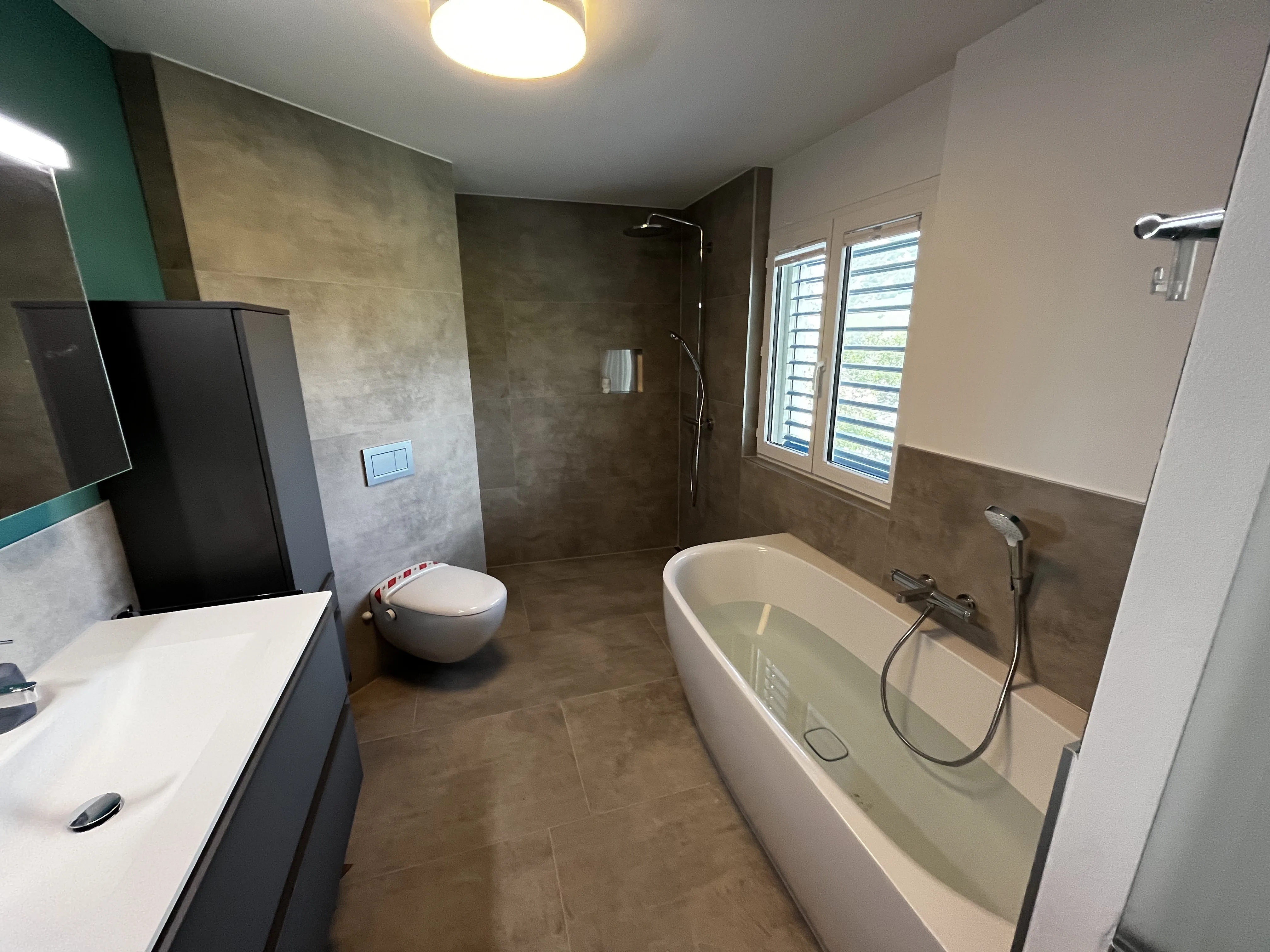 Modernes Badezimmer mit grauer Fliesengestaltung