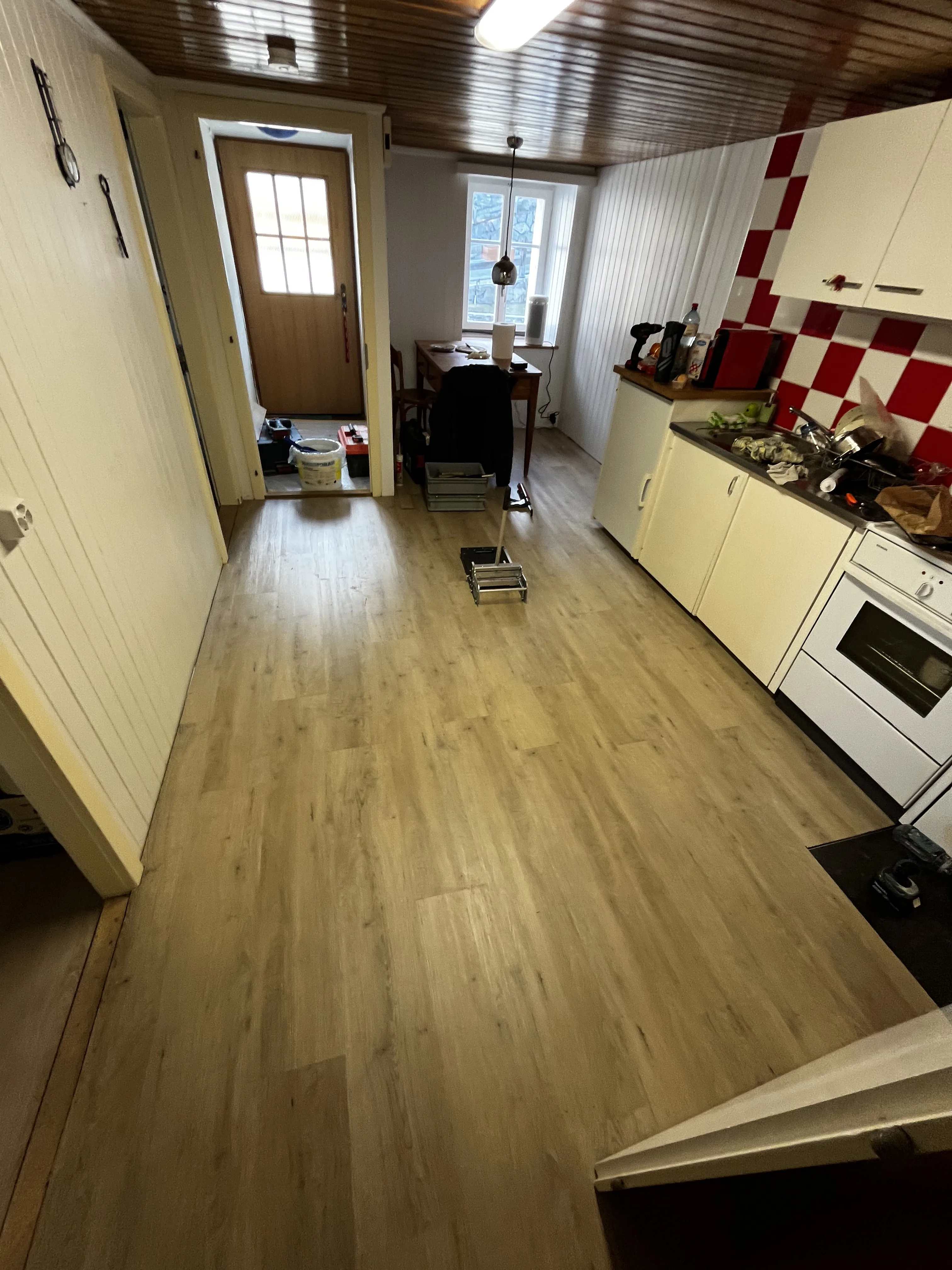 Renovierte Küche mit Holzboden und Fliesenspiegel