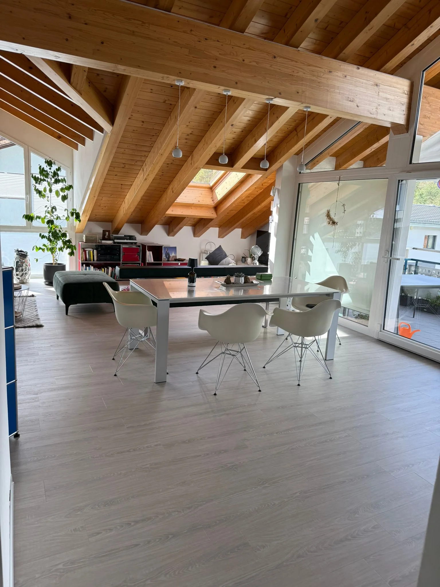 Moderner Dachausbau mit Holzbalken und Fensterfront