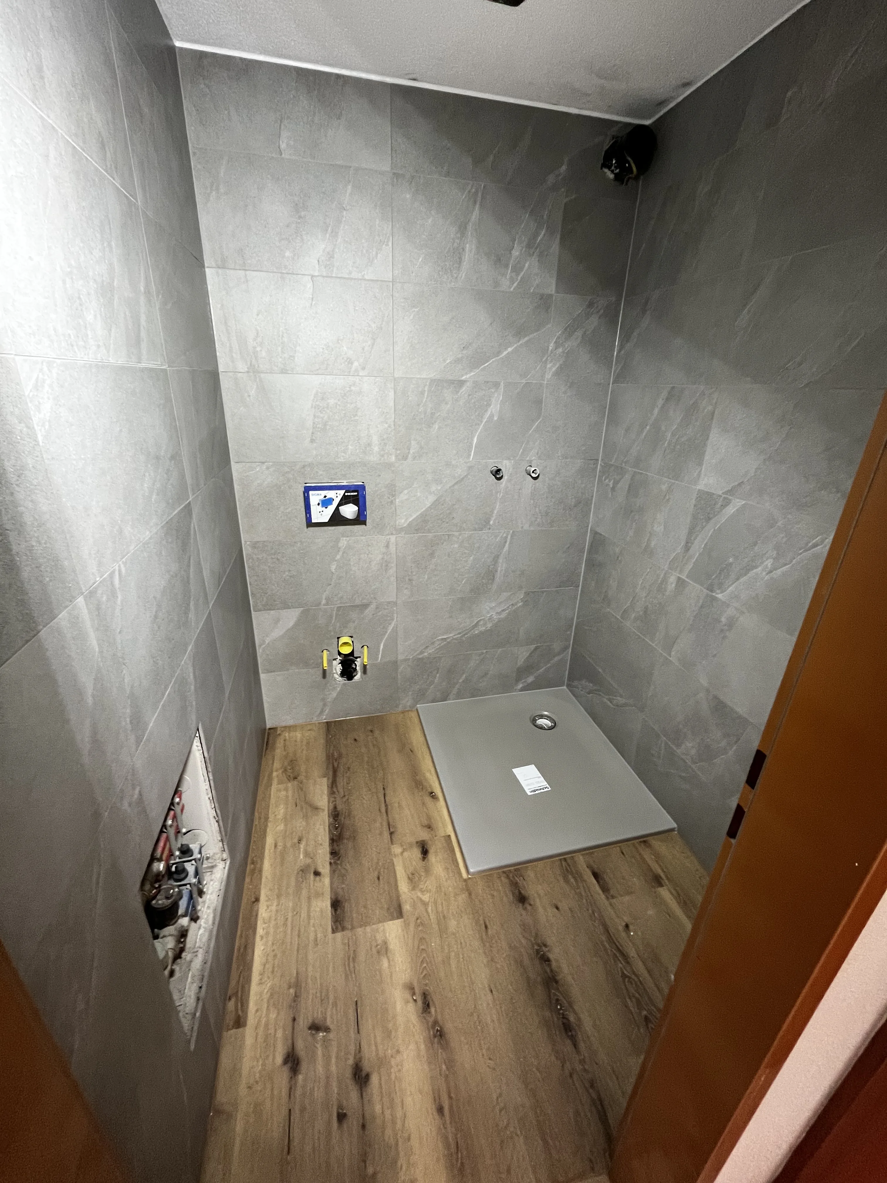 Moderne Dusche mit Natursteinfliesen und Holzboden