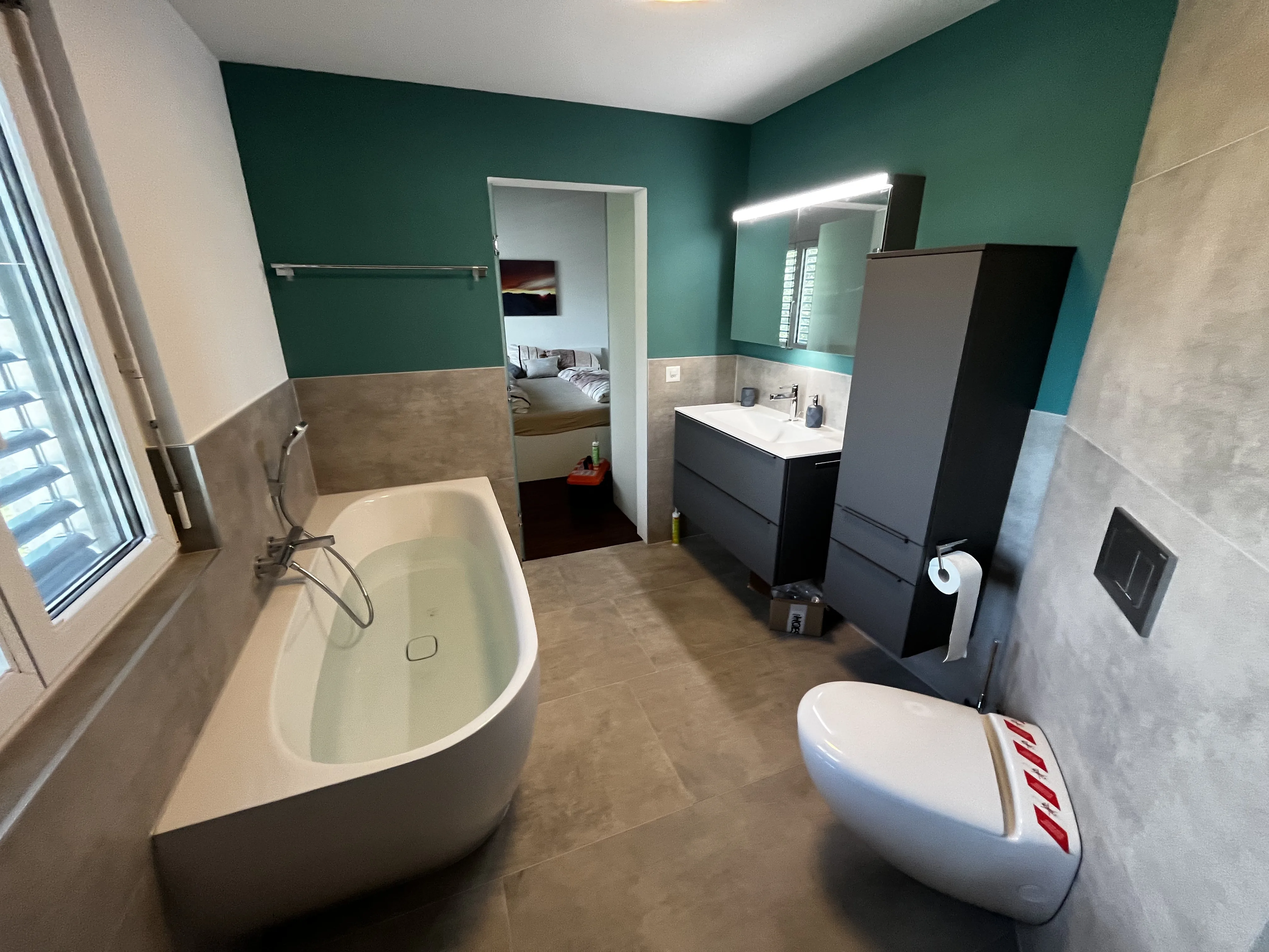 Modernes Badezimmer mit grüner Akzentwand