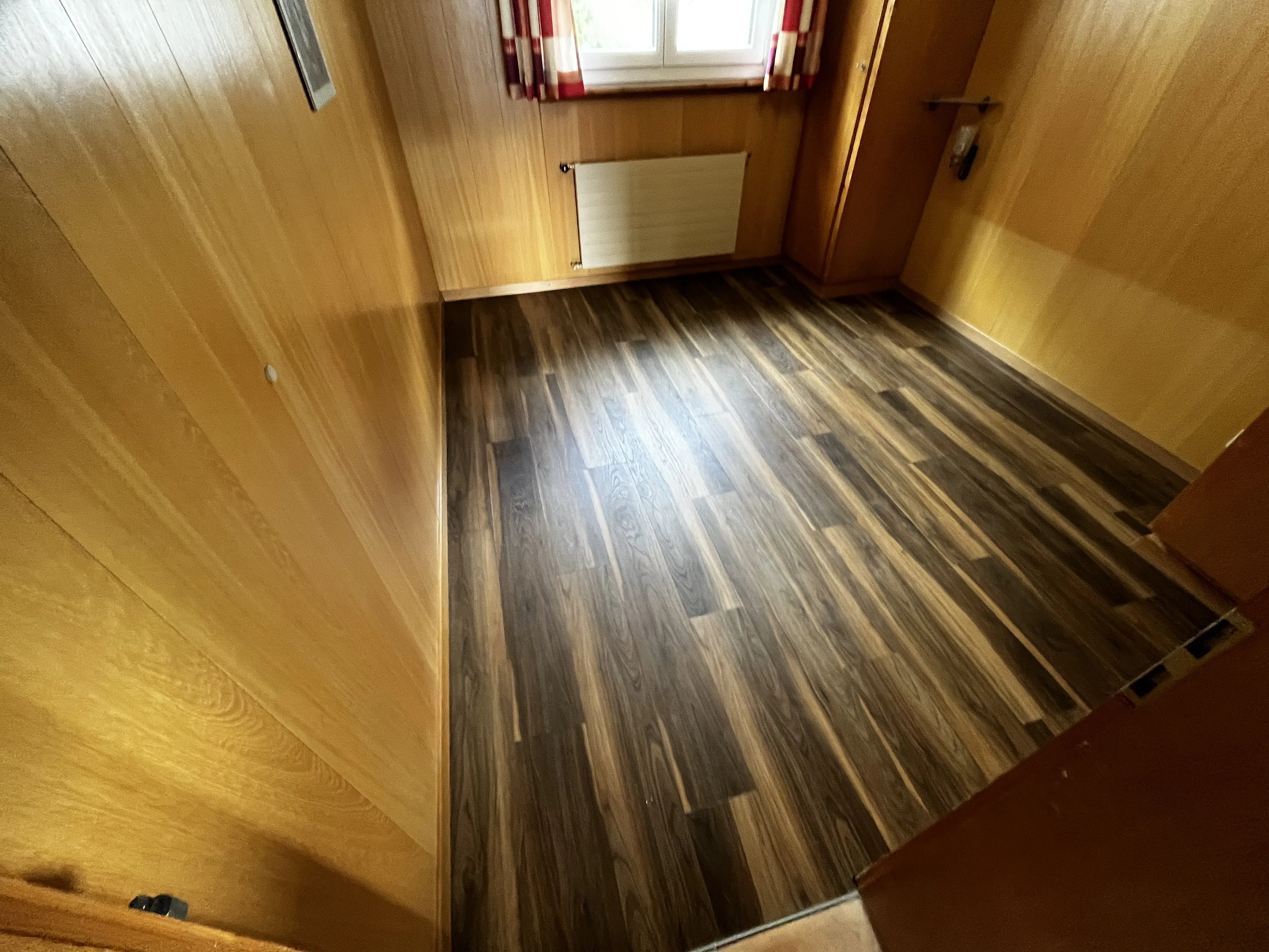Renoviertes Zimmer mit Holzboden und Verkleidung