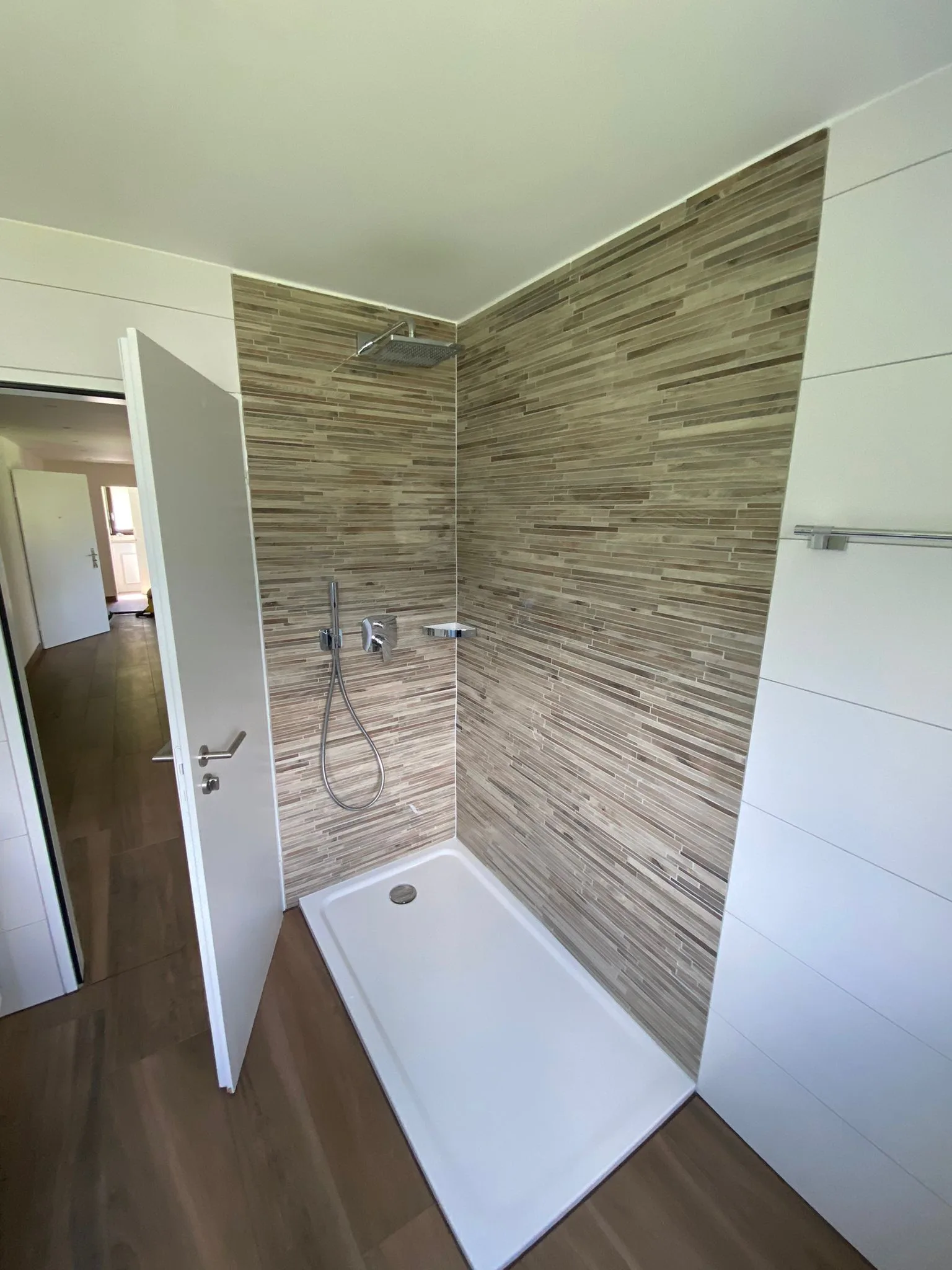 Modernes Badezimmer mit gefliestem Duschbereich und eleganten Wandplatten