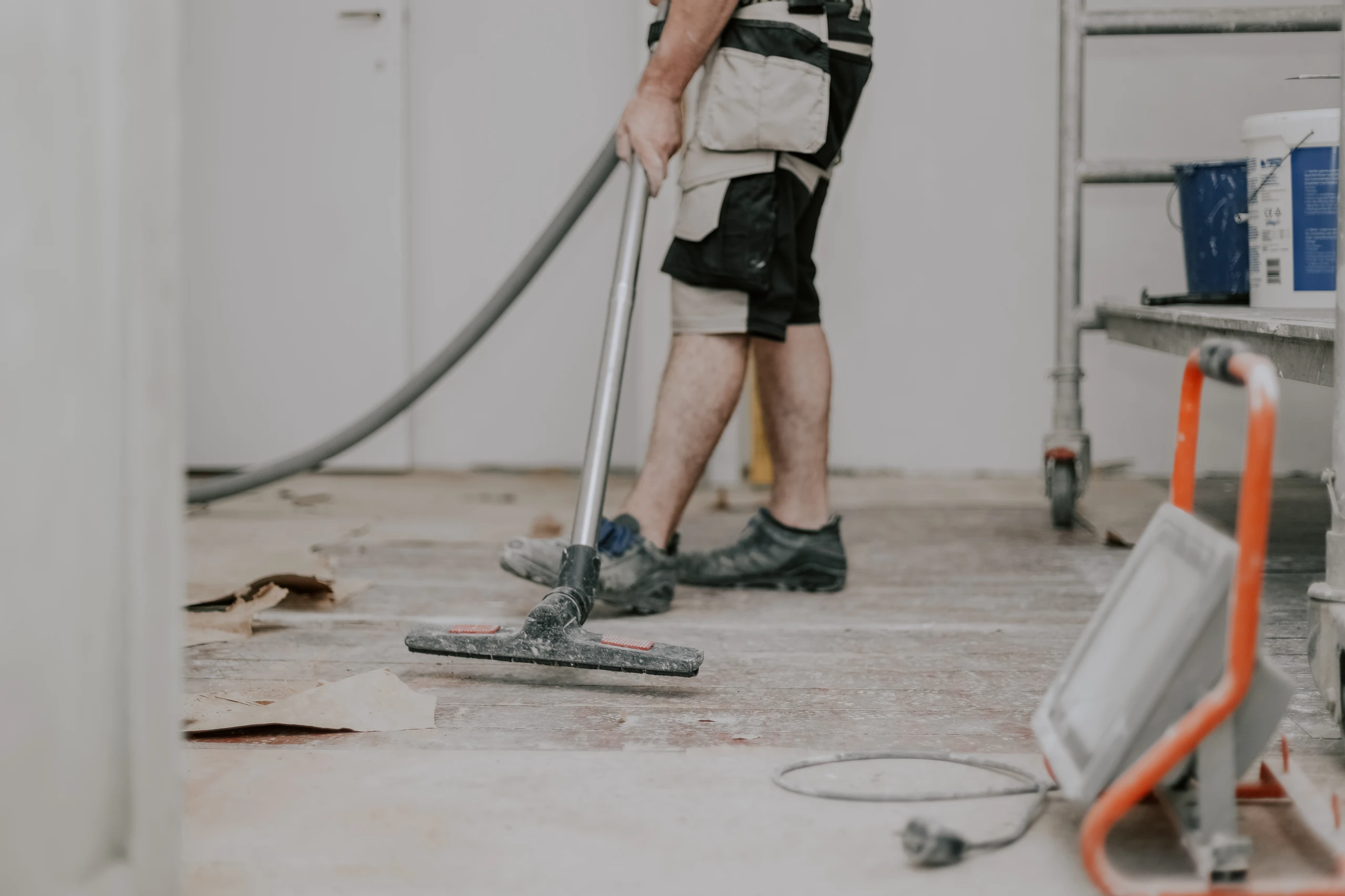 Reinigung der Baustelle mit einem Staubsauger durch einen Arbeiter