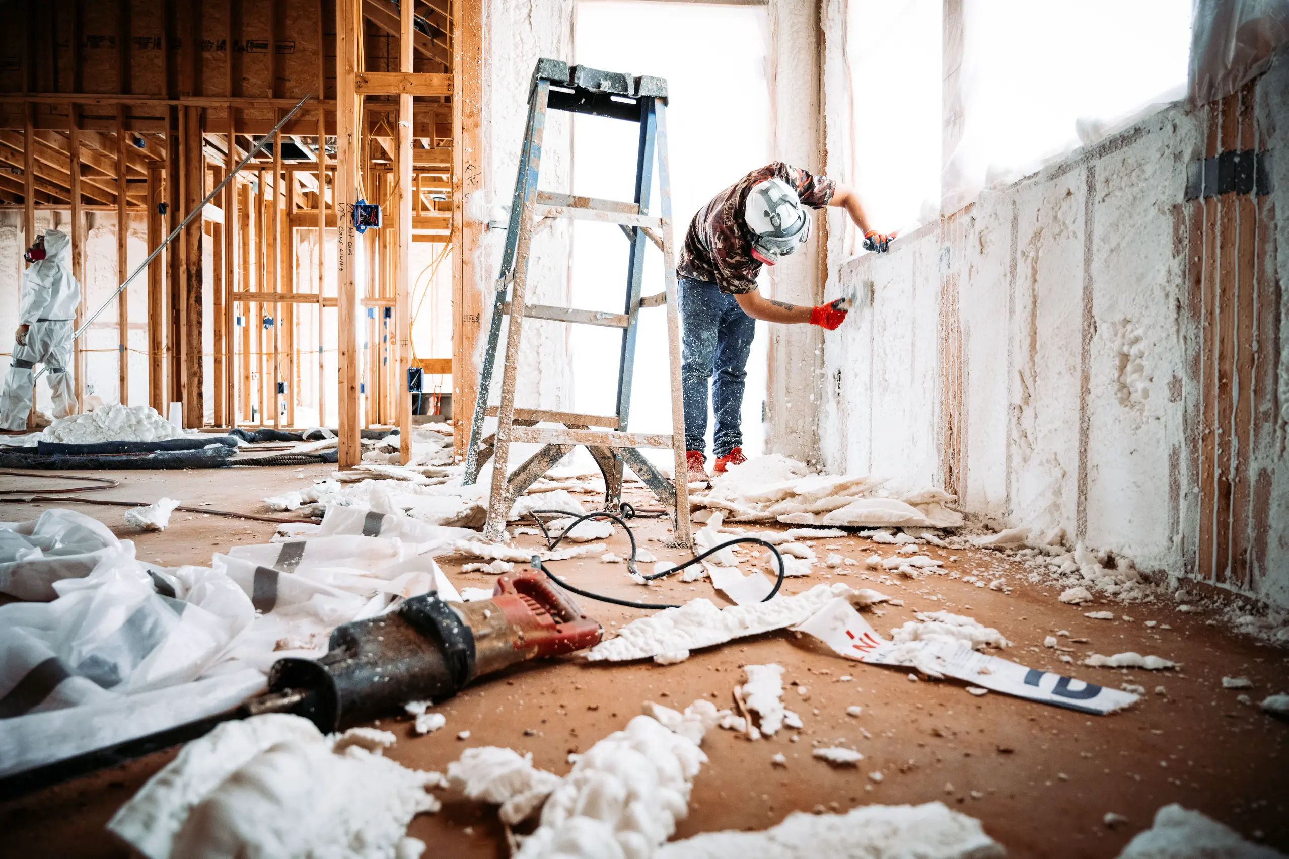 Handwerker bei der Renovierung mit Leiter, Werkzeug und Baustellenmaterial
