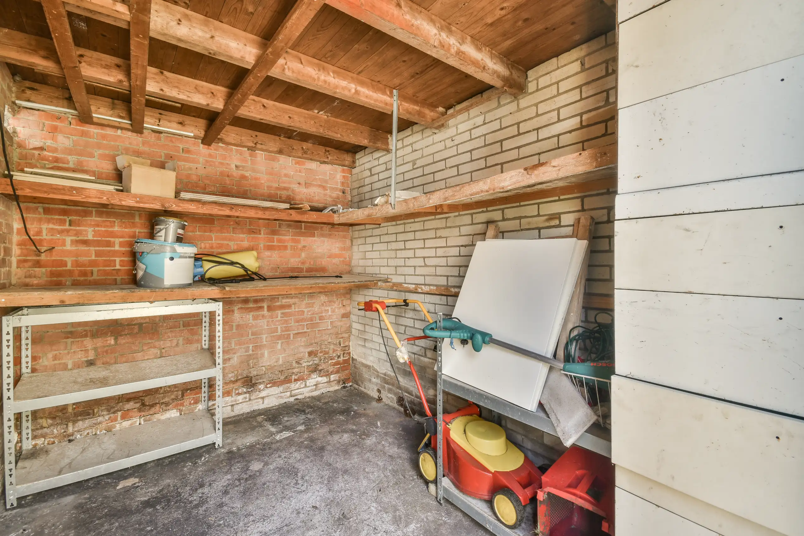 Aufgeräumter Keller mit Regalen und Arbeitsfläche für Renovierungsarbeiten