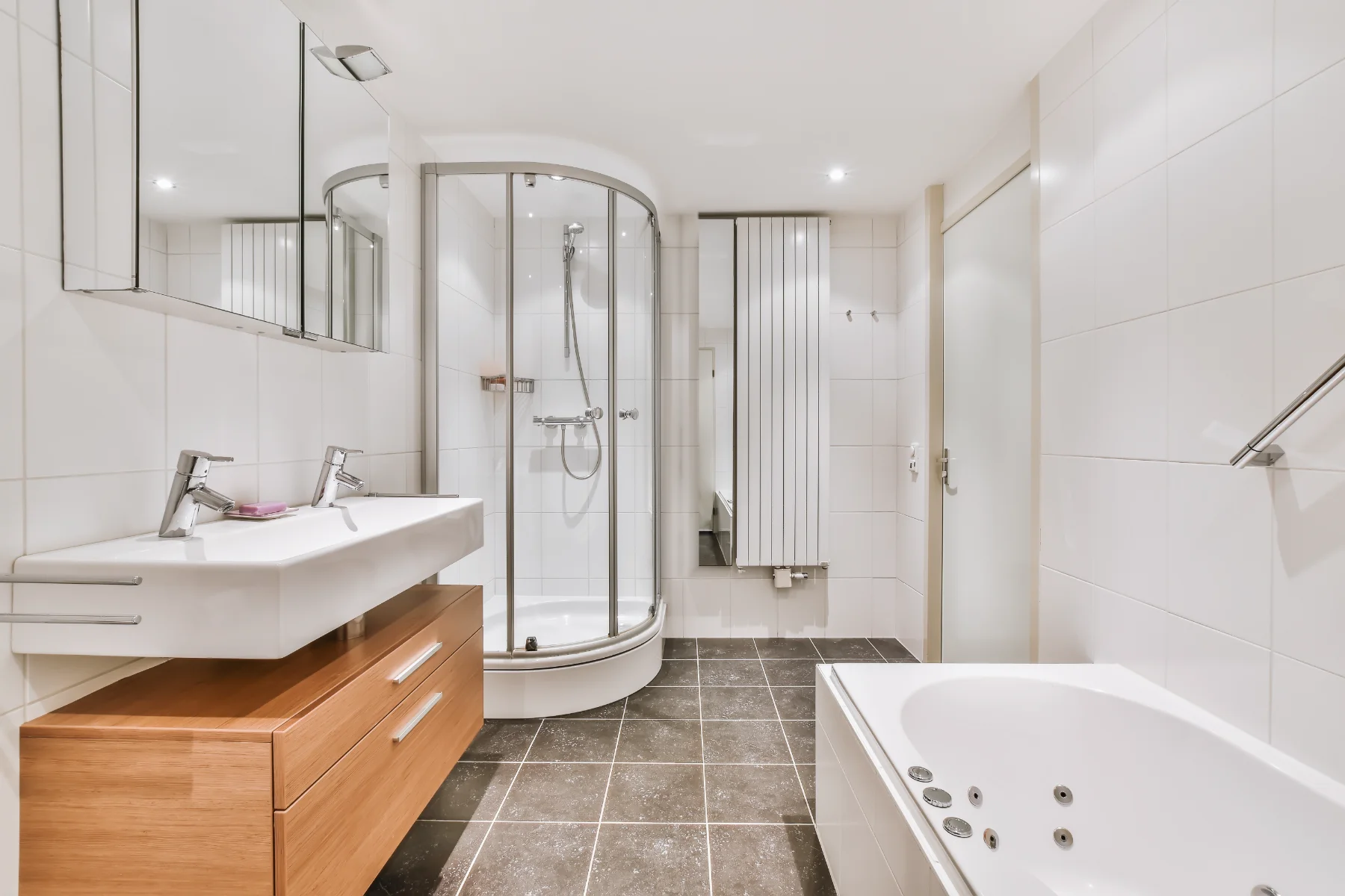 Modernes Badezimmer mit Dusche und Badewanne, Fliesenlegerarbeiten sichtbar