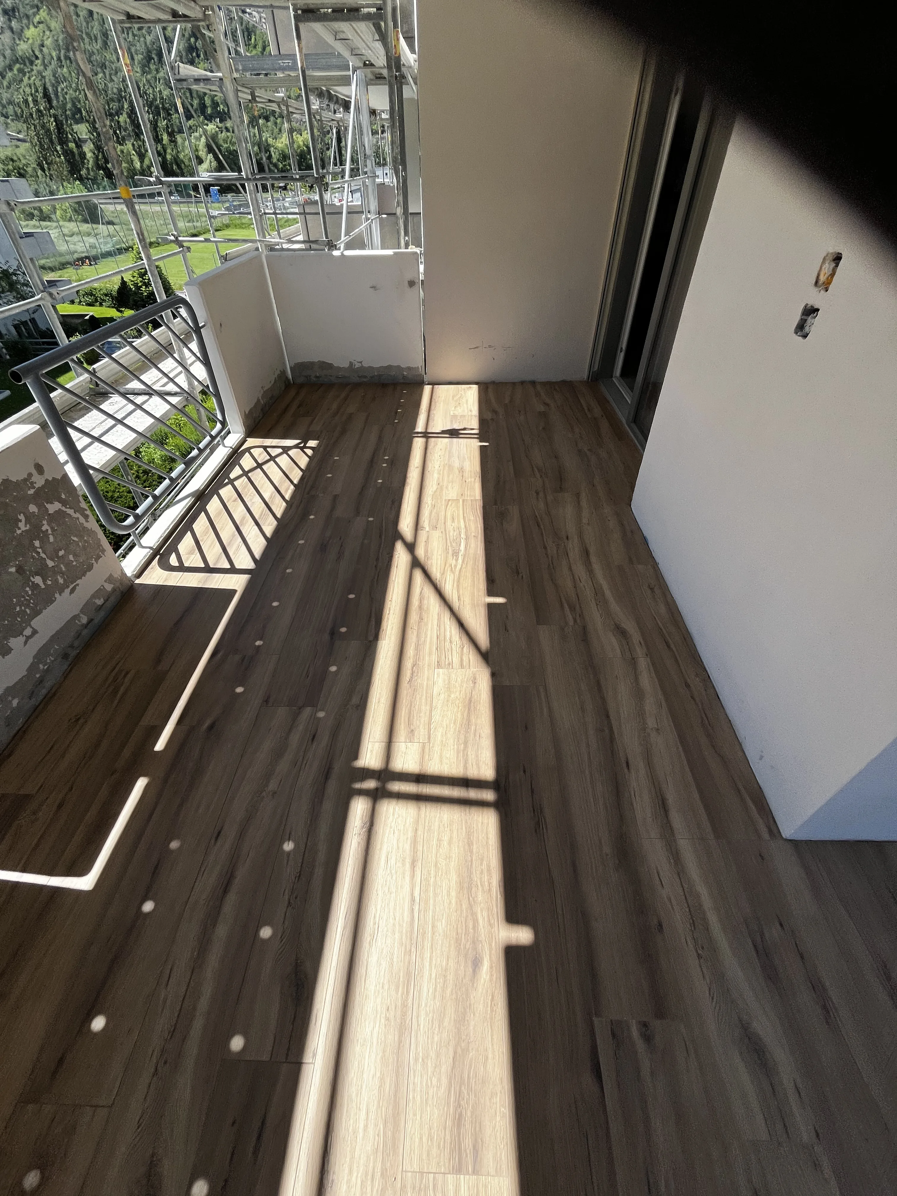 Neu verlegte Bodenplatten auf einem Balkon mit Sonnenschein