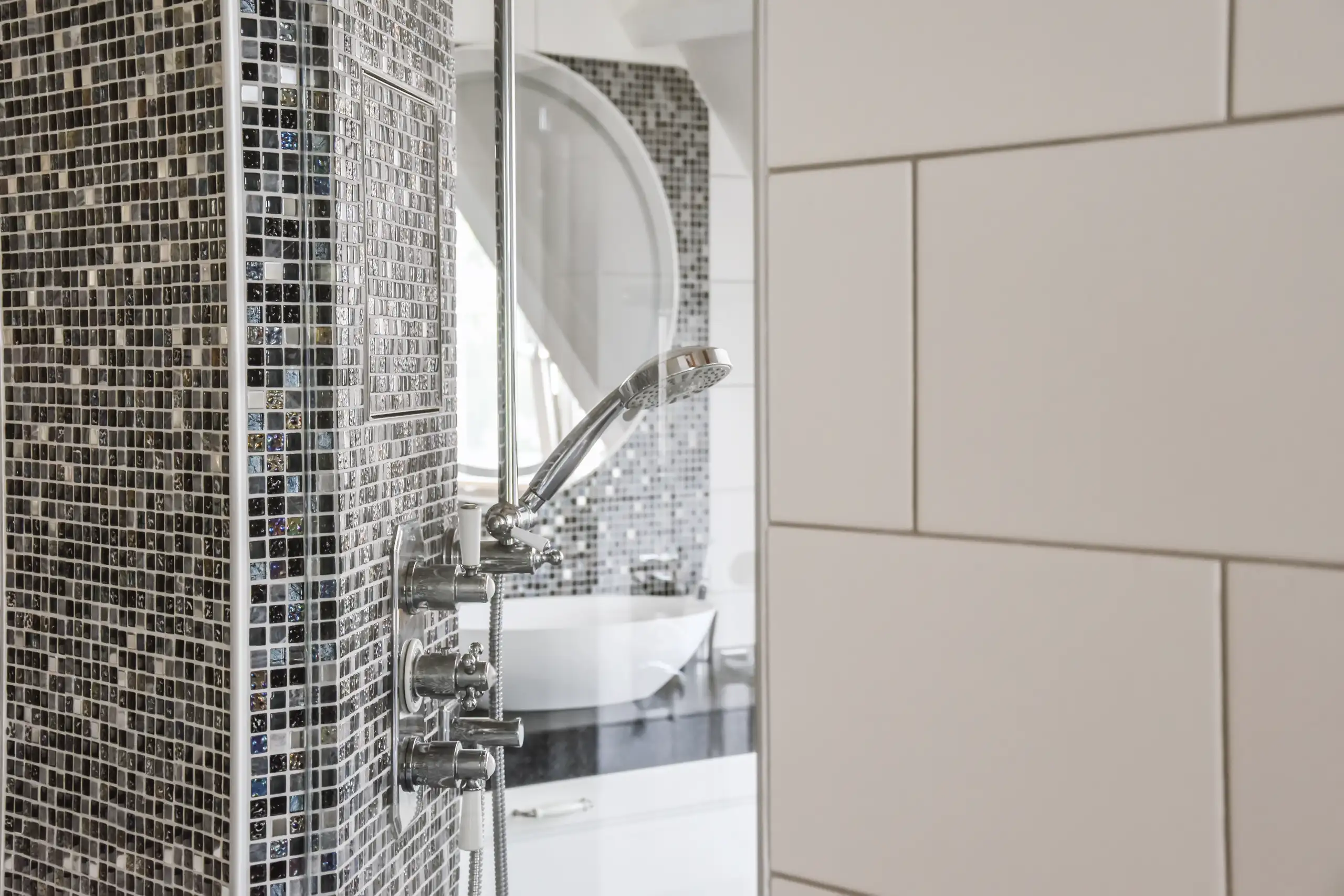 Detaillierte Ansicht einer modernen Dusche mit Fliesenverlegung und Duscharmatur