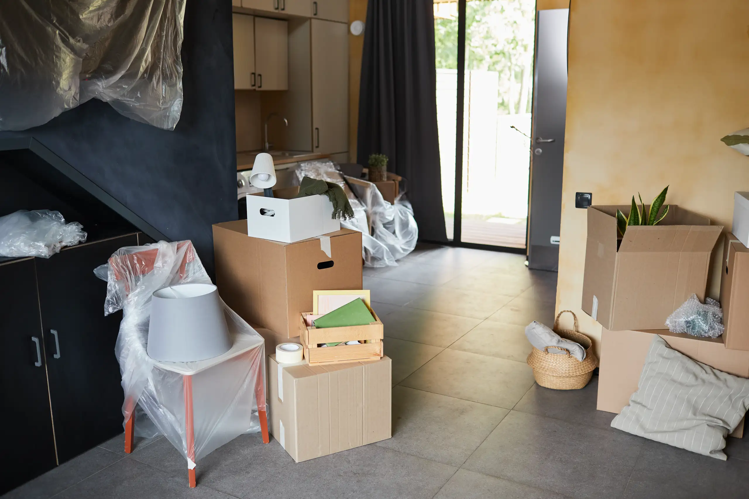 Eingepackte Möbel und Umzugskartons in einem Raum während der Wohnungsräumung