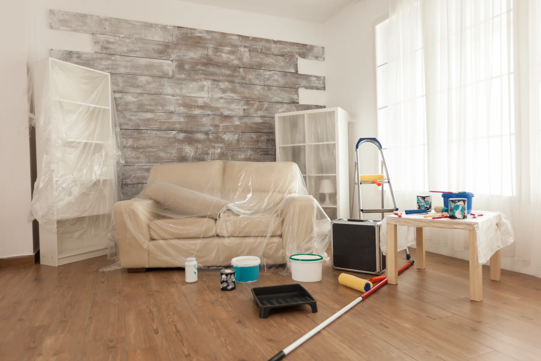 Wohnungsrenovation mit unordentlichem Arbeitsplatz und Materialien für Malerarbeiten